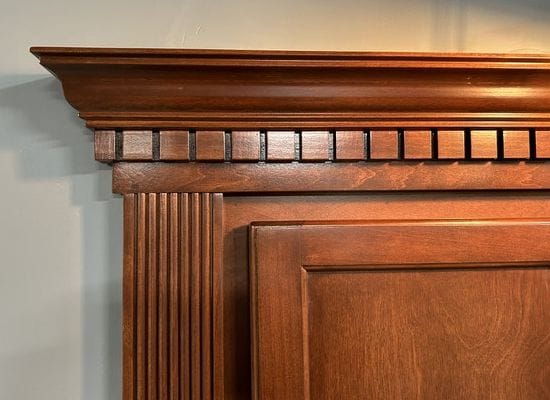 Crown and dentil molding above a hidden bookcase door