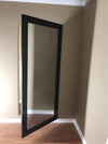 Hide-A-Way Doors hidden mirror door with black frame partially open in beige room