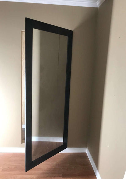Hide-A-Way-Doors hidden mirror door with black frame seamlessly integrated into wall in room