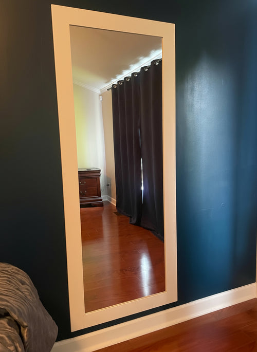Hide-A-Way Doors hidden mirror door mounted on dark blue wall reflecting room with wooden floor