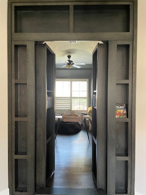 Finished custom hidden door wall unit shown open