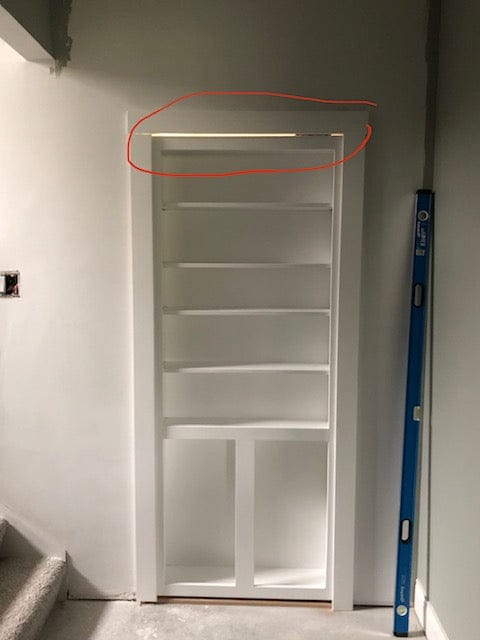 Visible light gap above an out-swing hidden bookcase door
