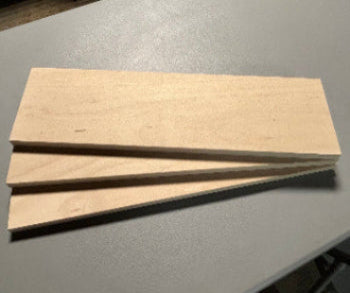 Adjustable bookcase shelf panels made of light-colored wood stacked on a gray surface