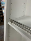 Close-up of white real wood shoe rack shelf with metal rail inside cabinet