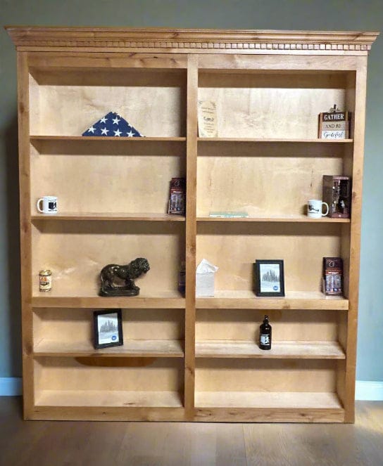 BiFold bookcase door made in alder wood with clear cost and crown molding