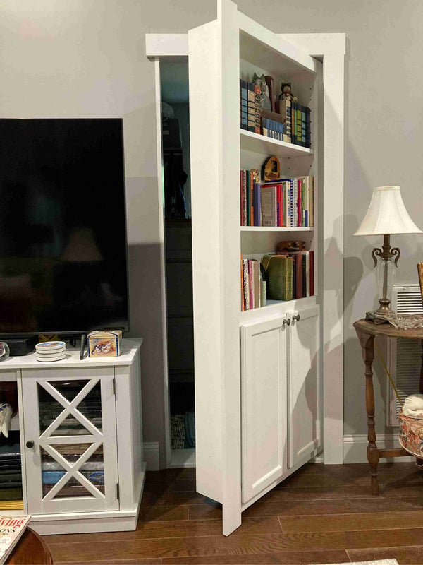 White hidden bookcase door with books and decorative items in a living room setting.