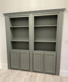 Gray hidden bookcase door by Hide-A-Way-Doors with shelves and cabinet doors in a home interior